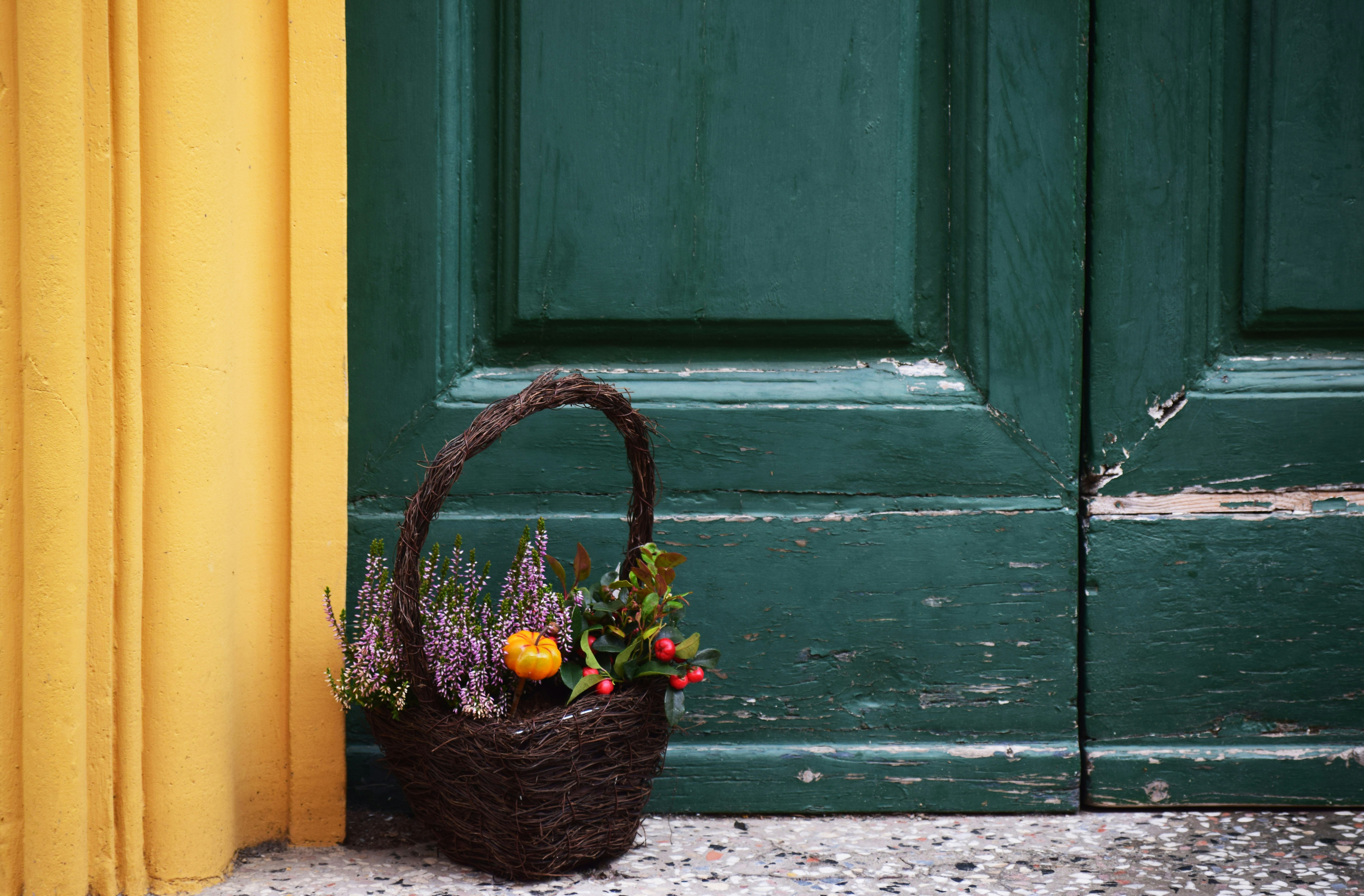 brown basket filled with flower near door